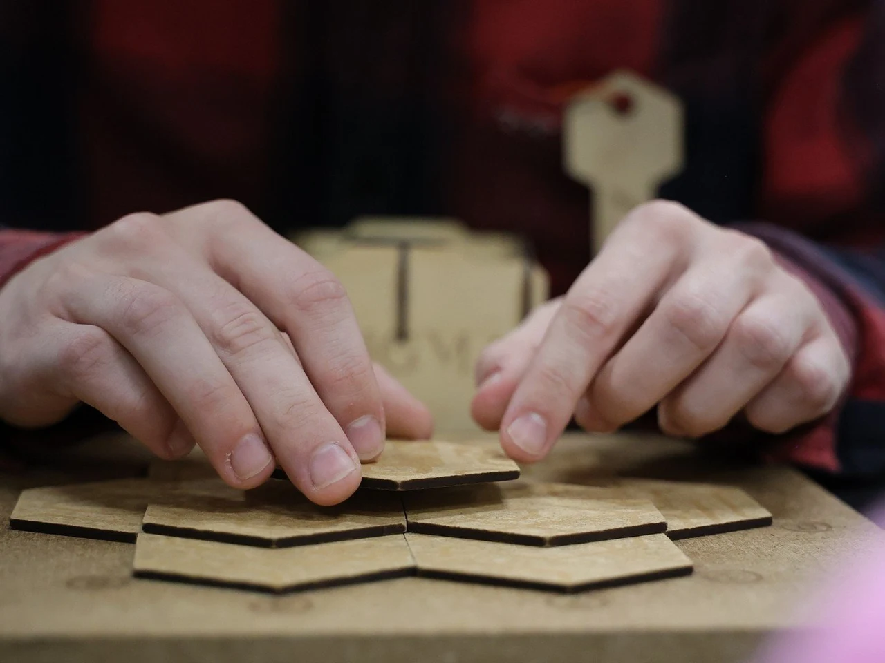Une main complète un puzzle Enigma en bois